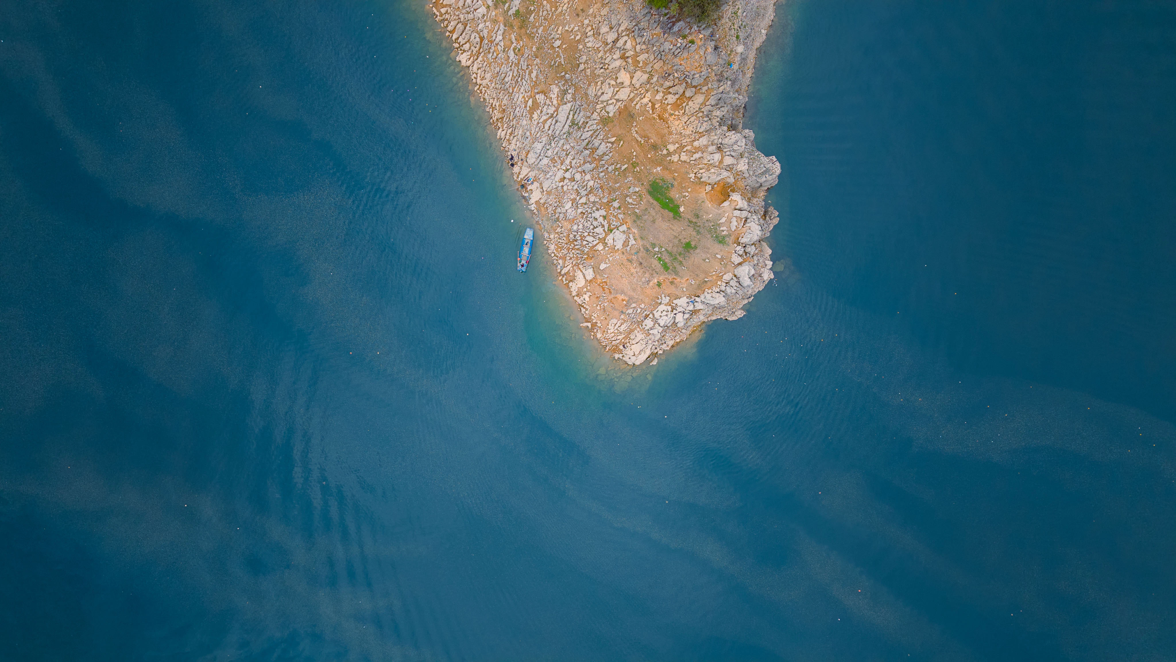 A rocky island surrounded by calm, blue water.