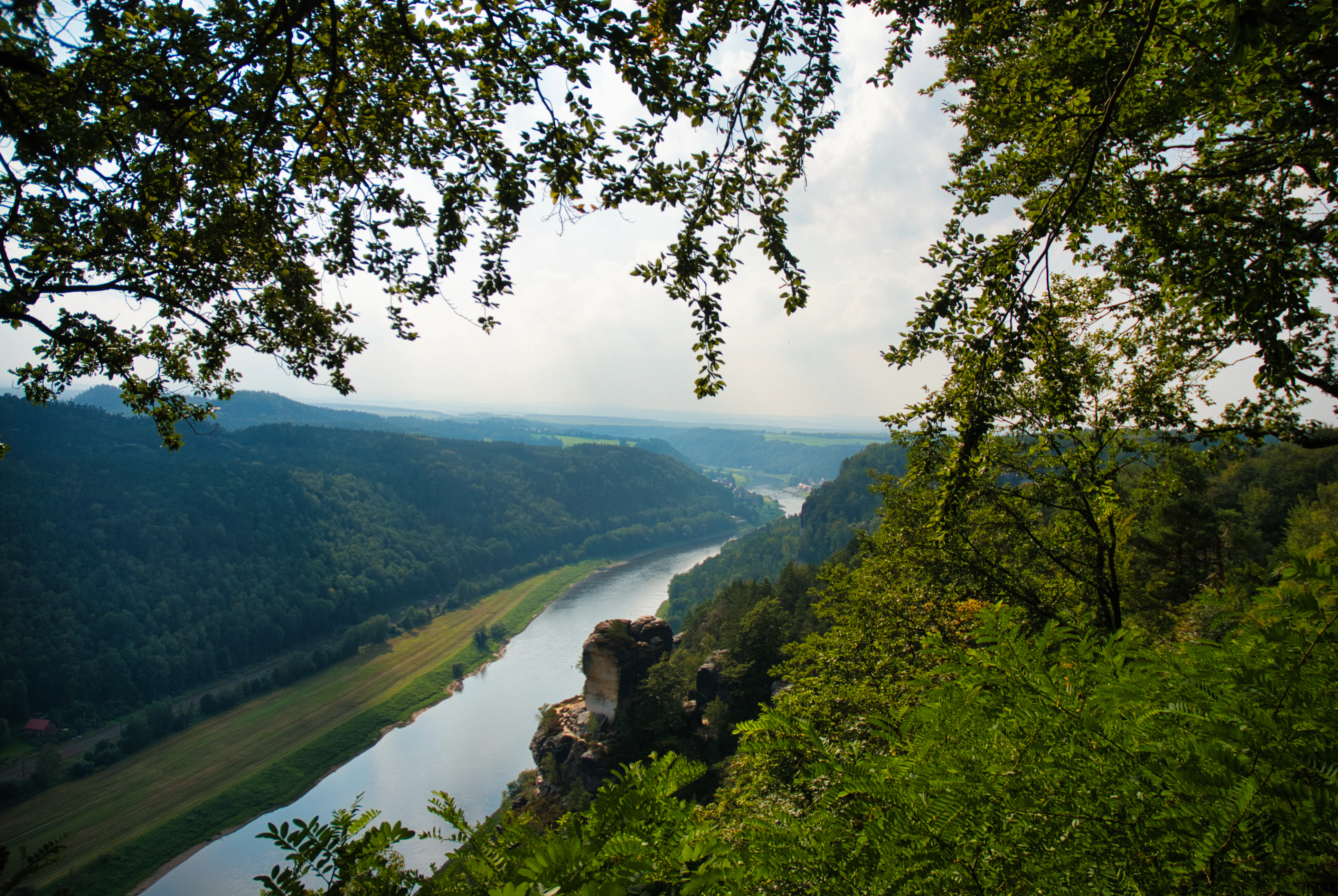 River flowing through a lush green valley with trees.