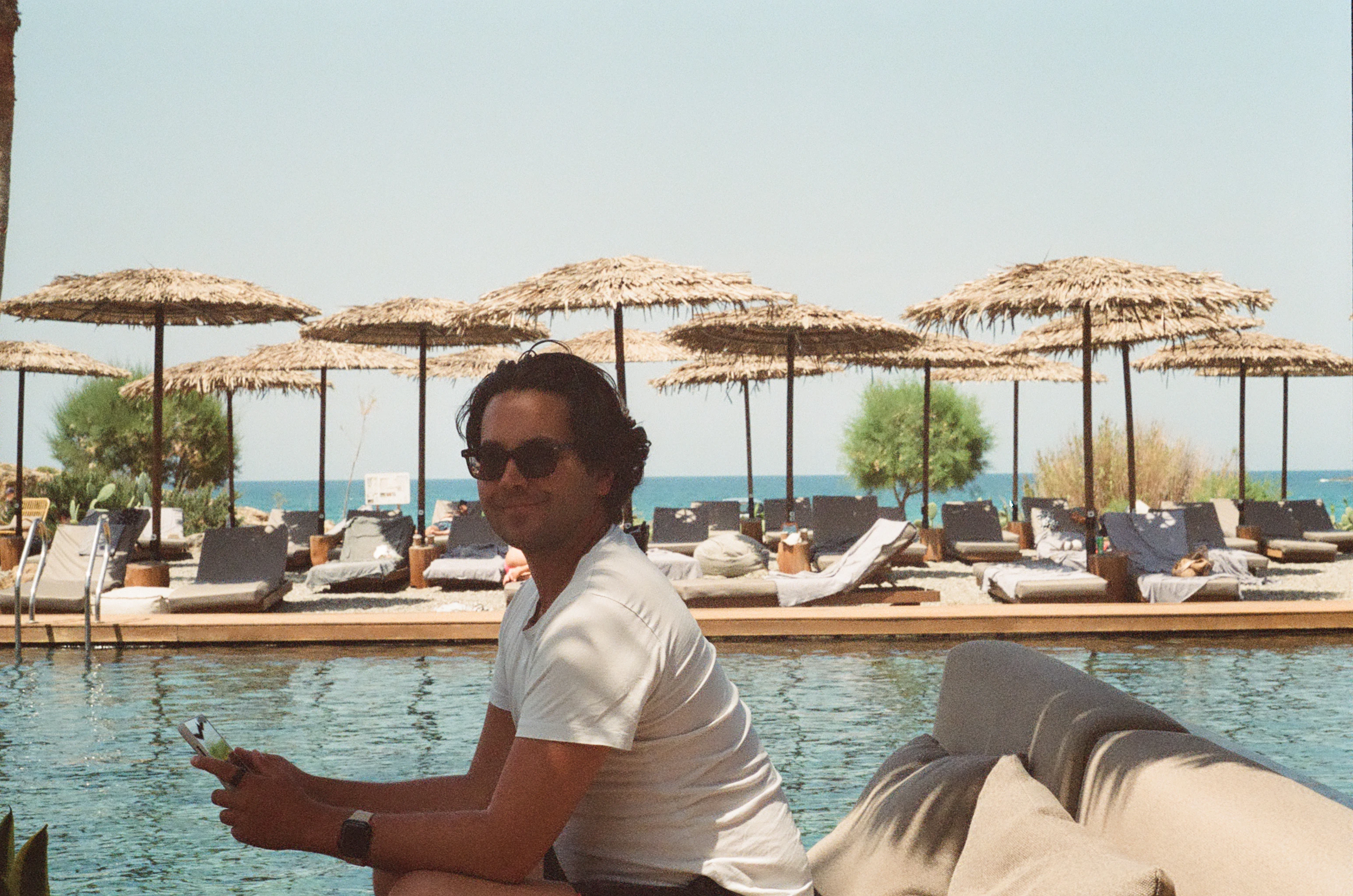 A man sitting on the edge of a swimming pool