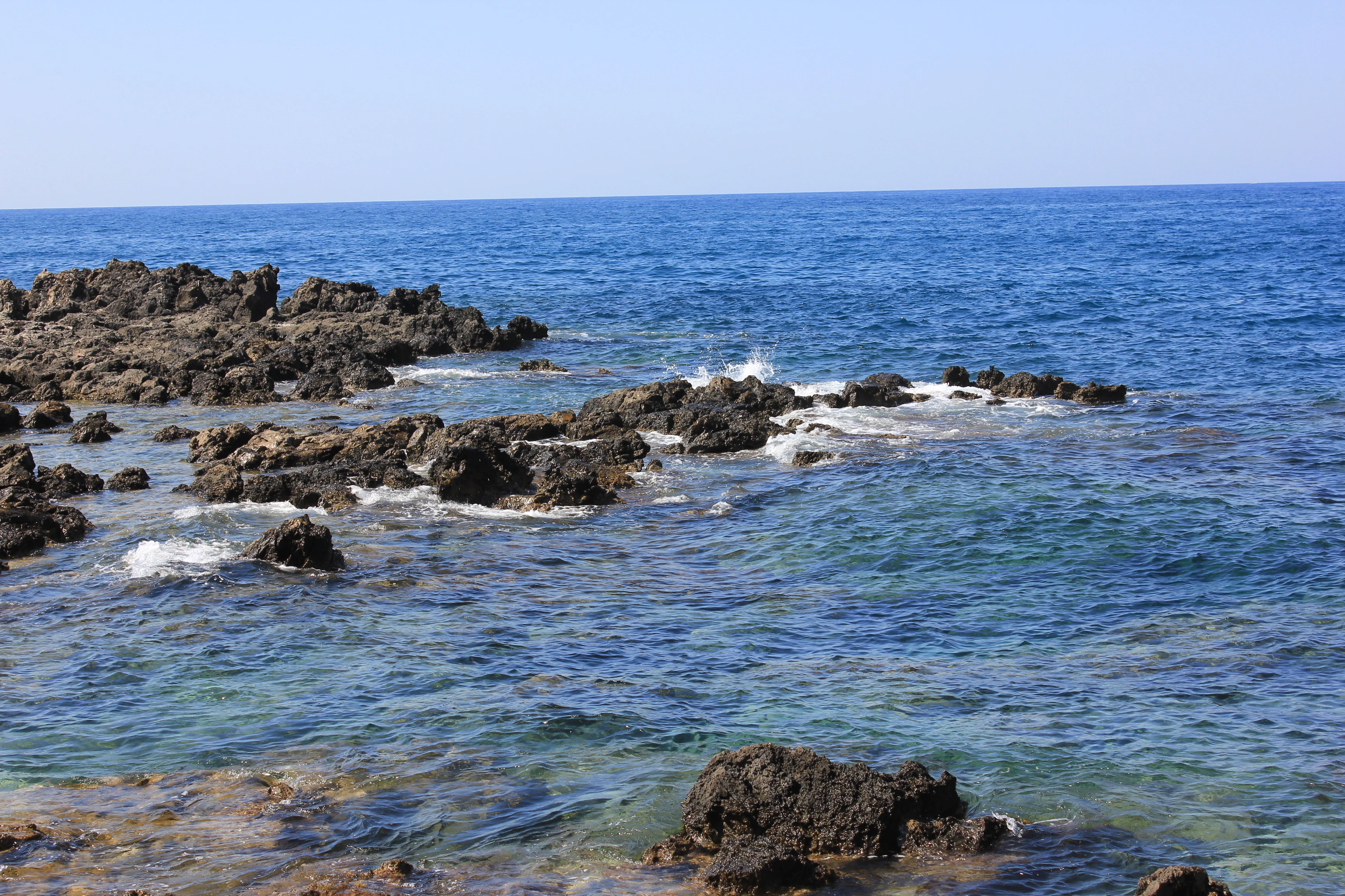 a rocky beach with blue water