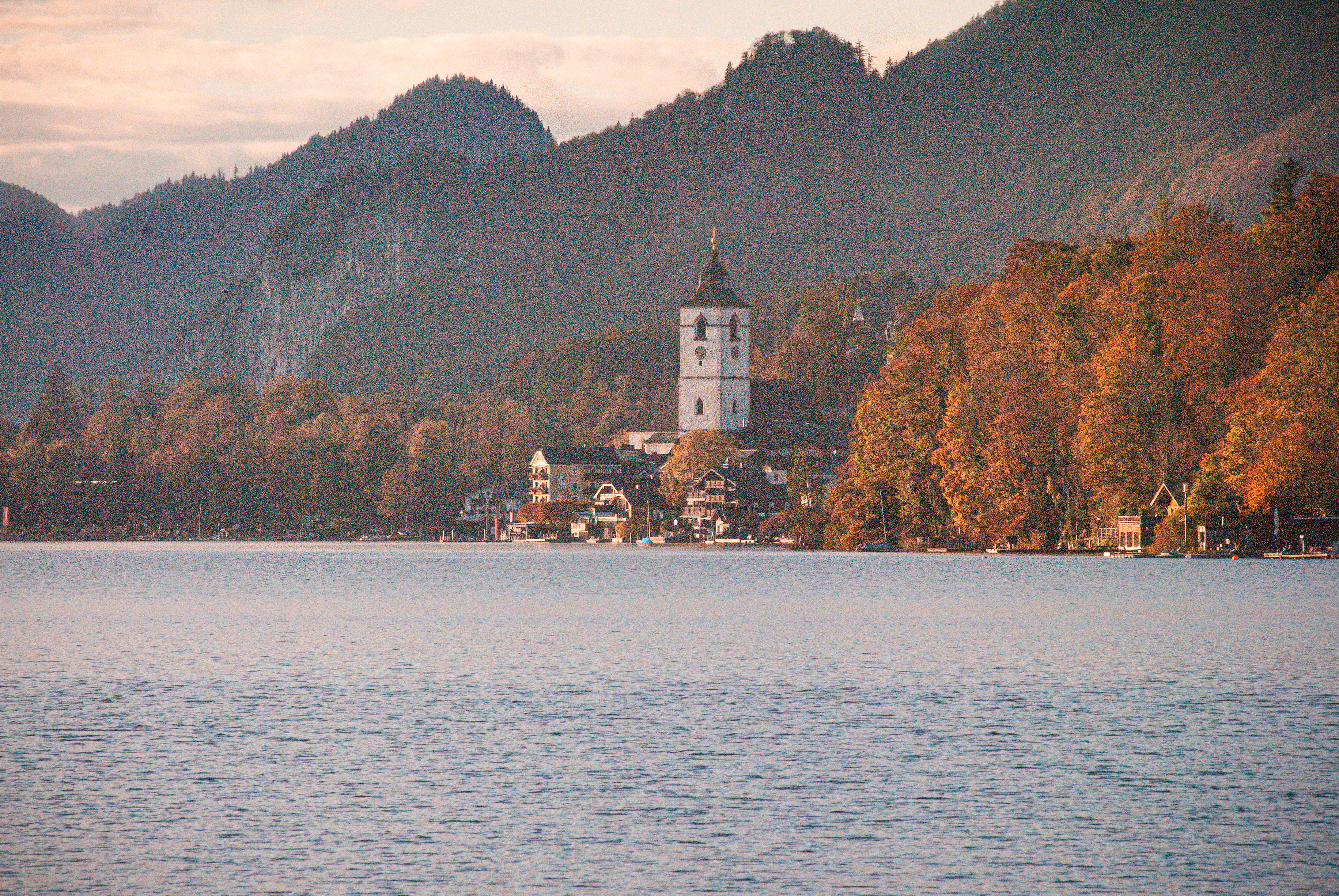 a building on a hill by a body of water
