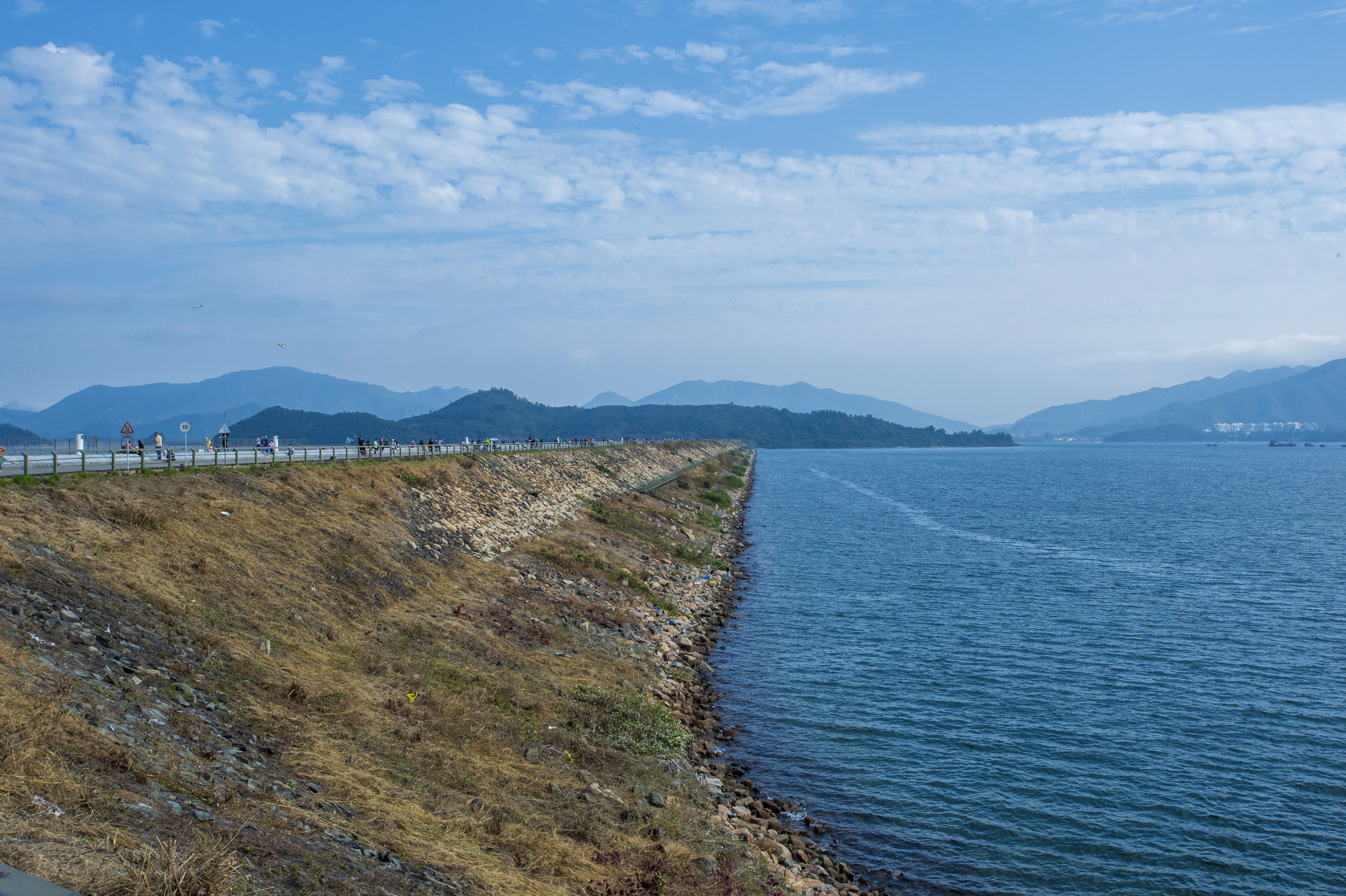 a body of water next to a hill with a boat in it