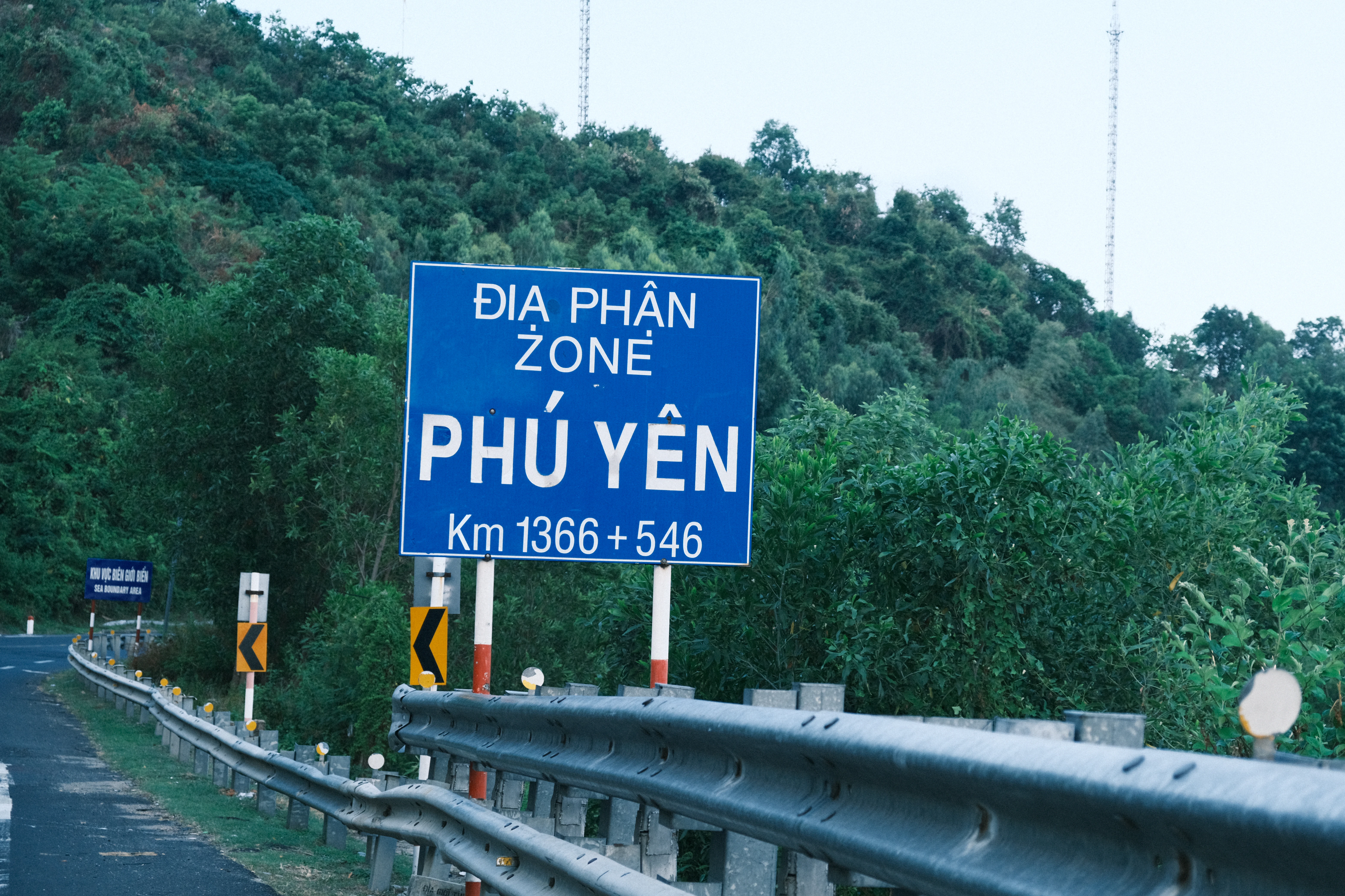 Blue sign indicating phu yen zone on a roadside.