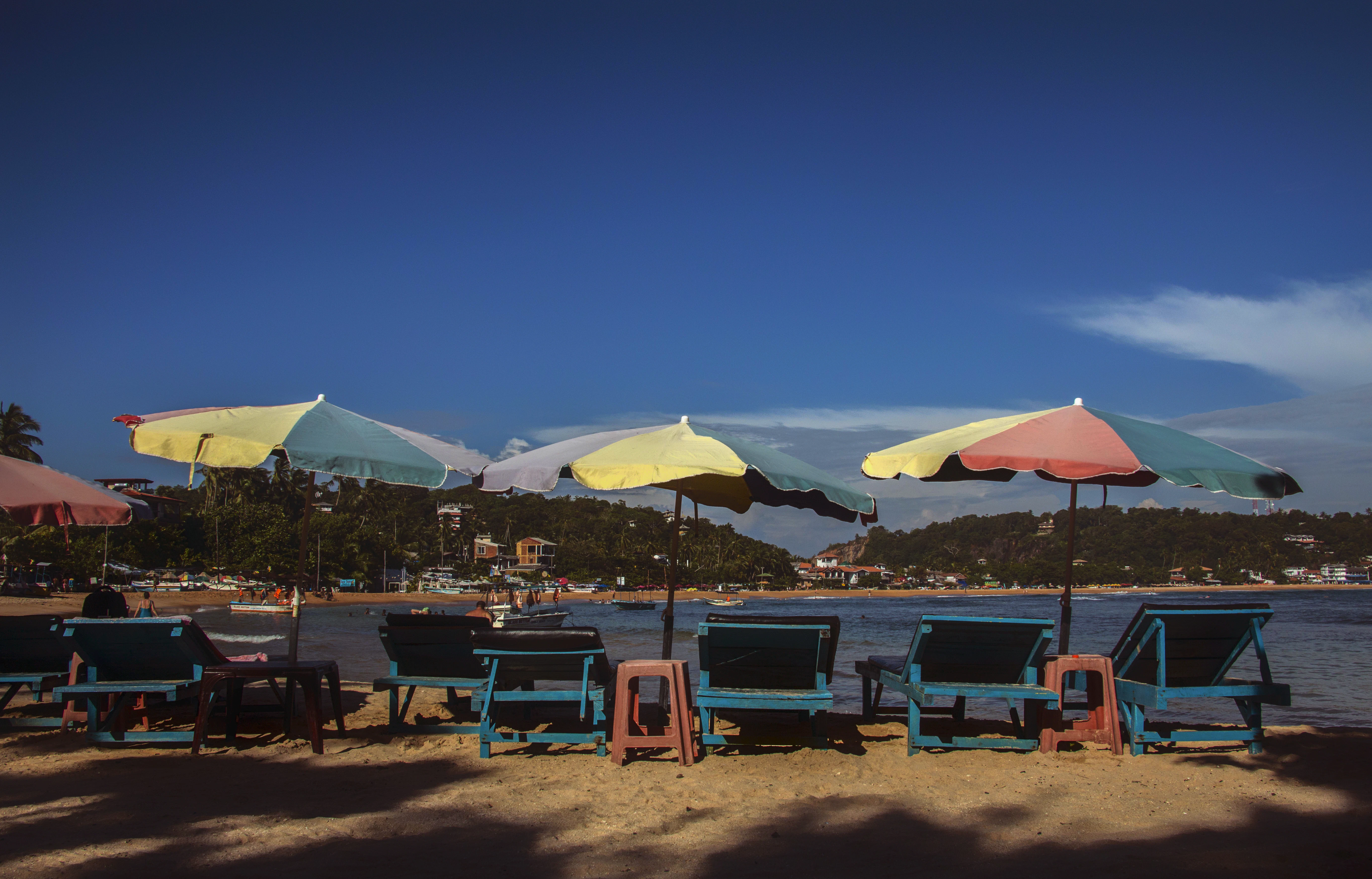 Beach chairs and umbrellas under a clear blue sky.