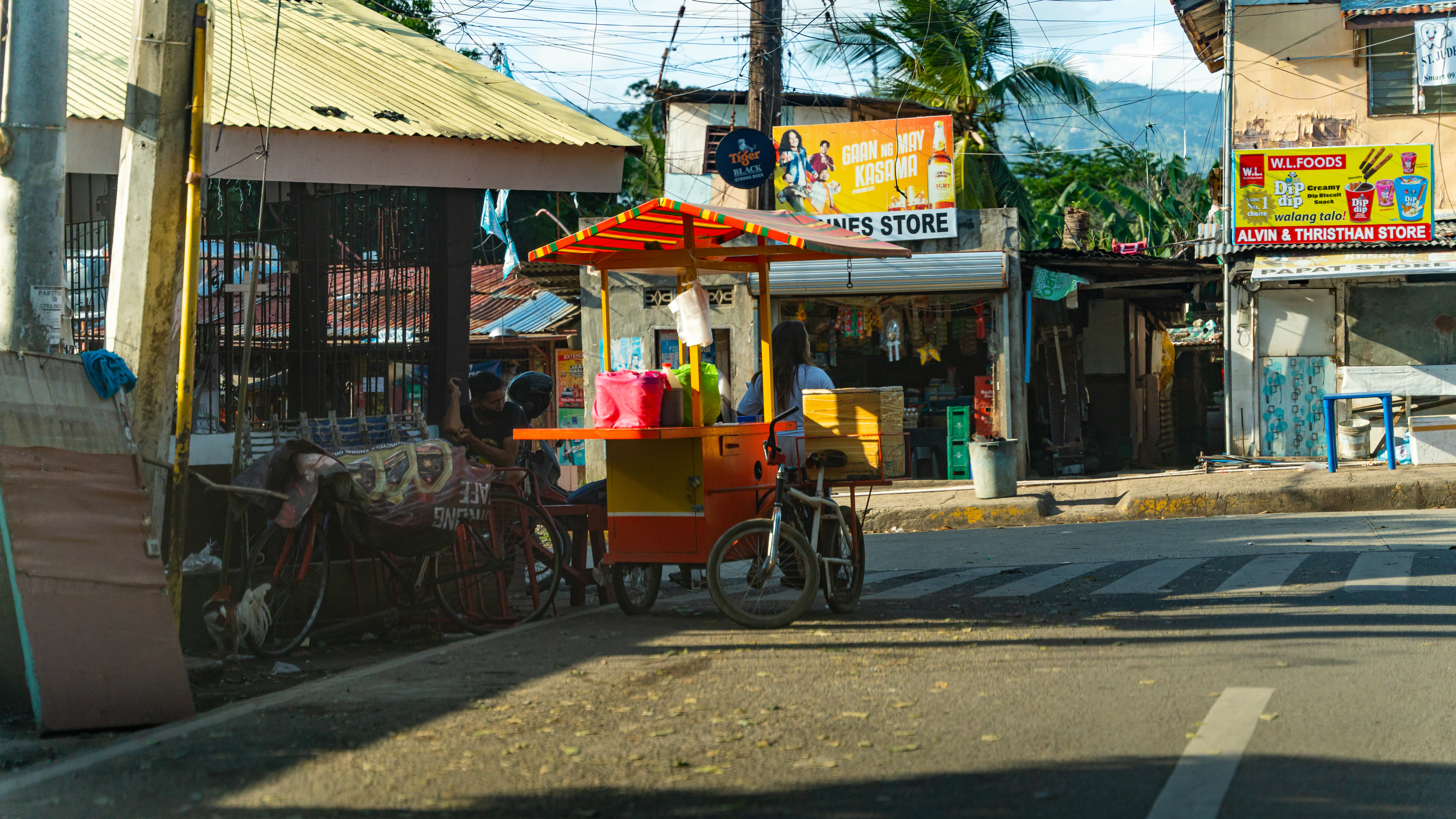 a street scene with a street vendor on the side of the road