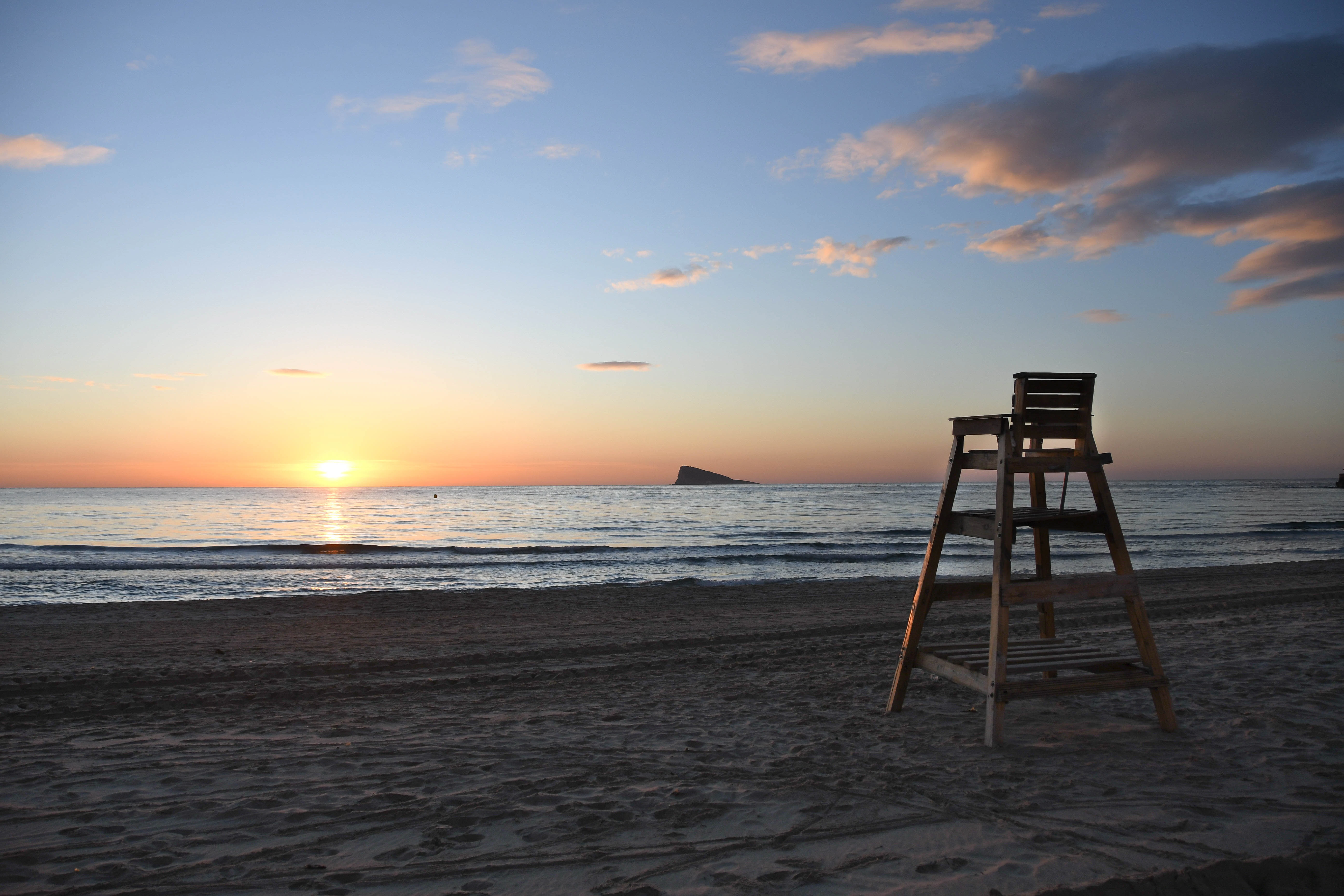 brown wooden chair on beach during sunset