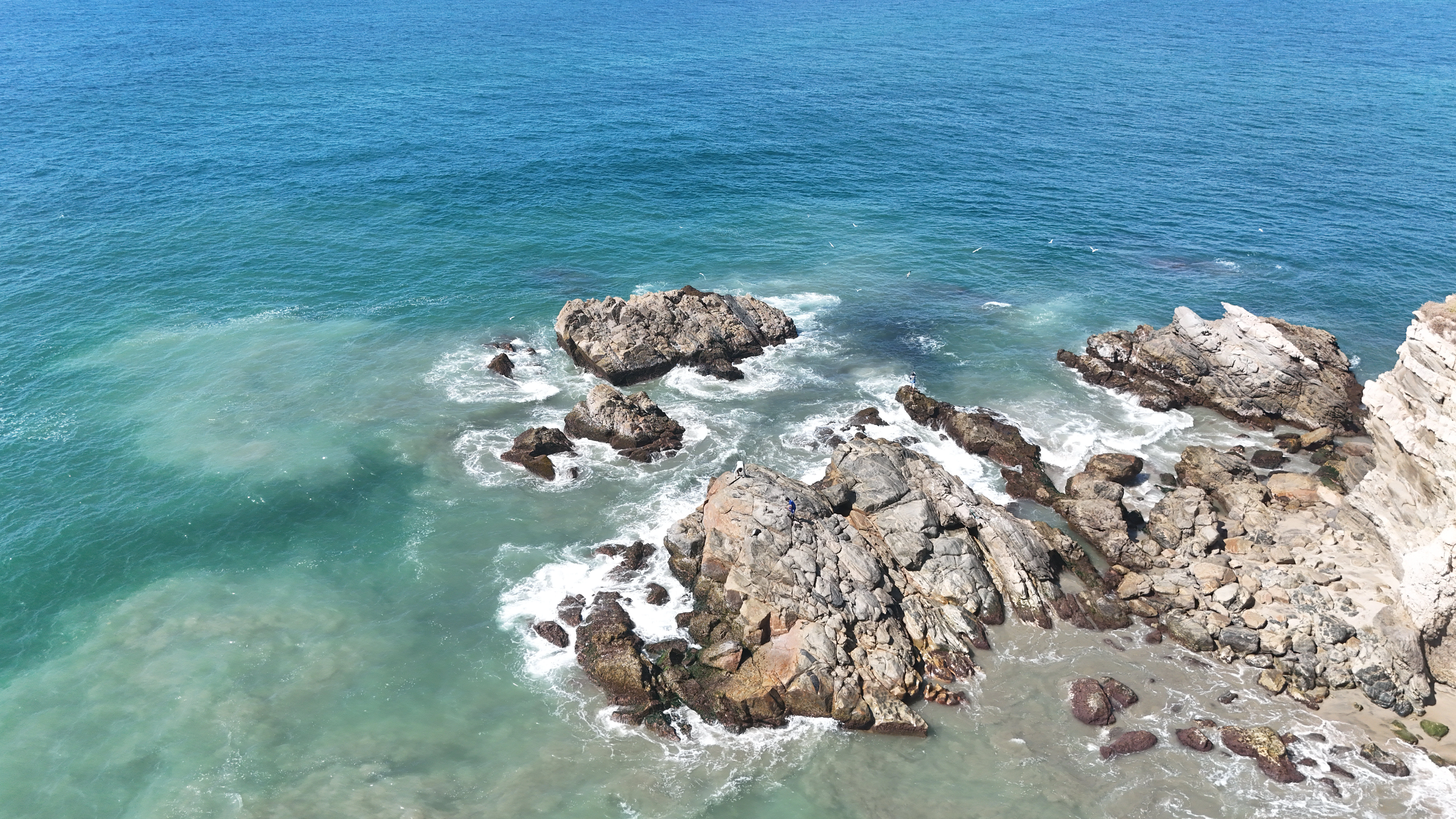 Waves crashing against rocky coastal formations.