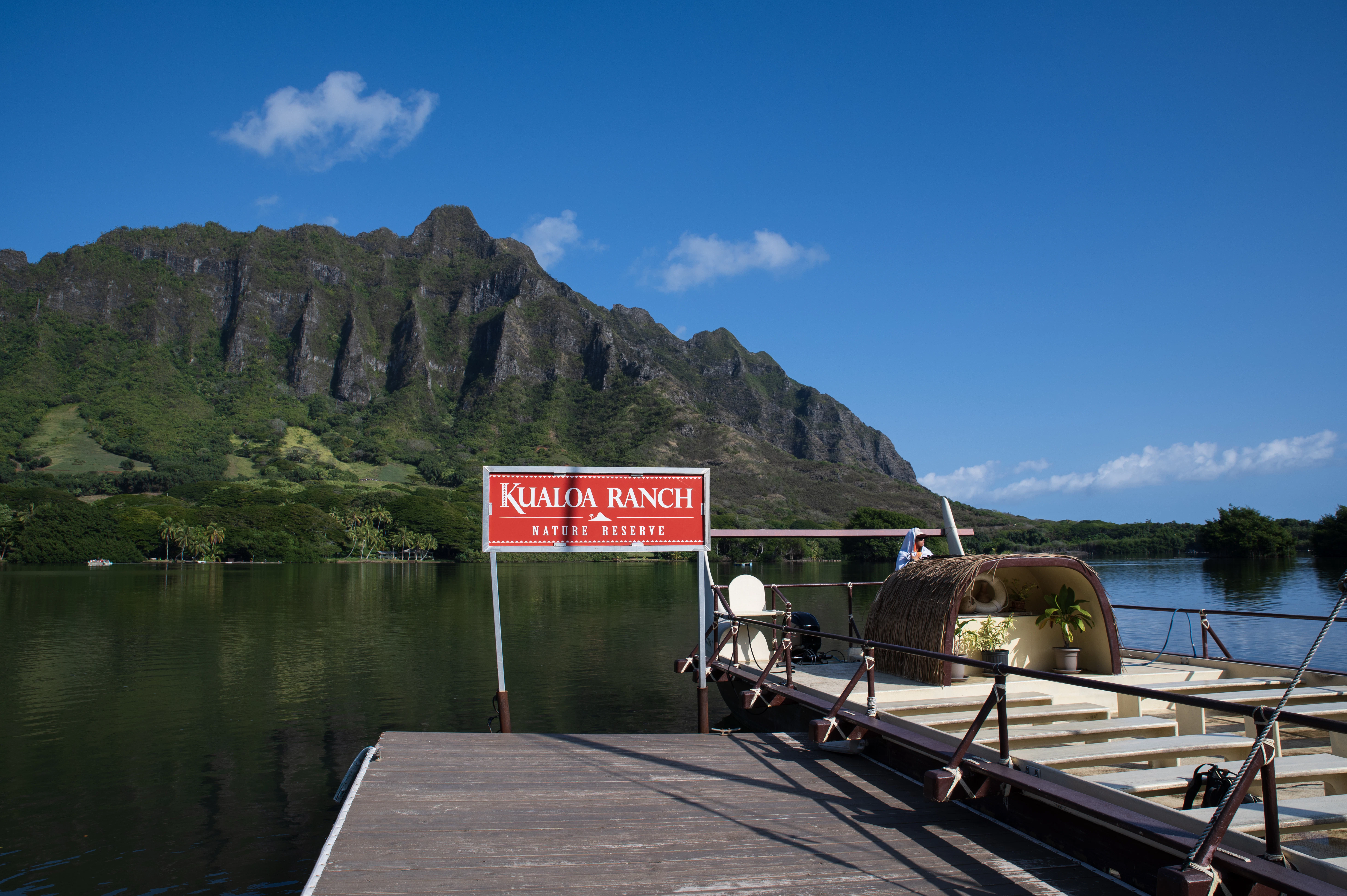 Kualoa ranch sign on a dock with mountains