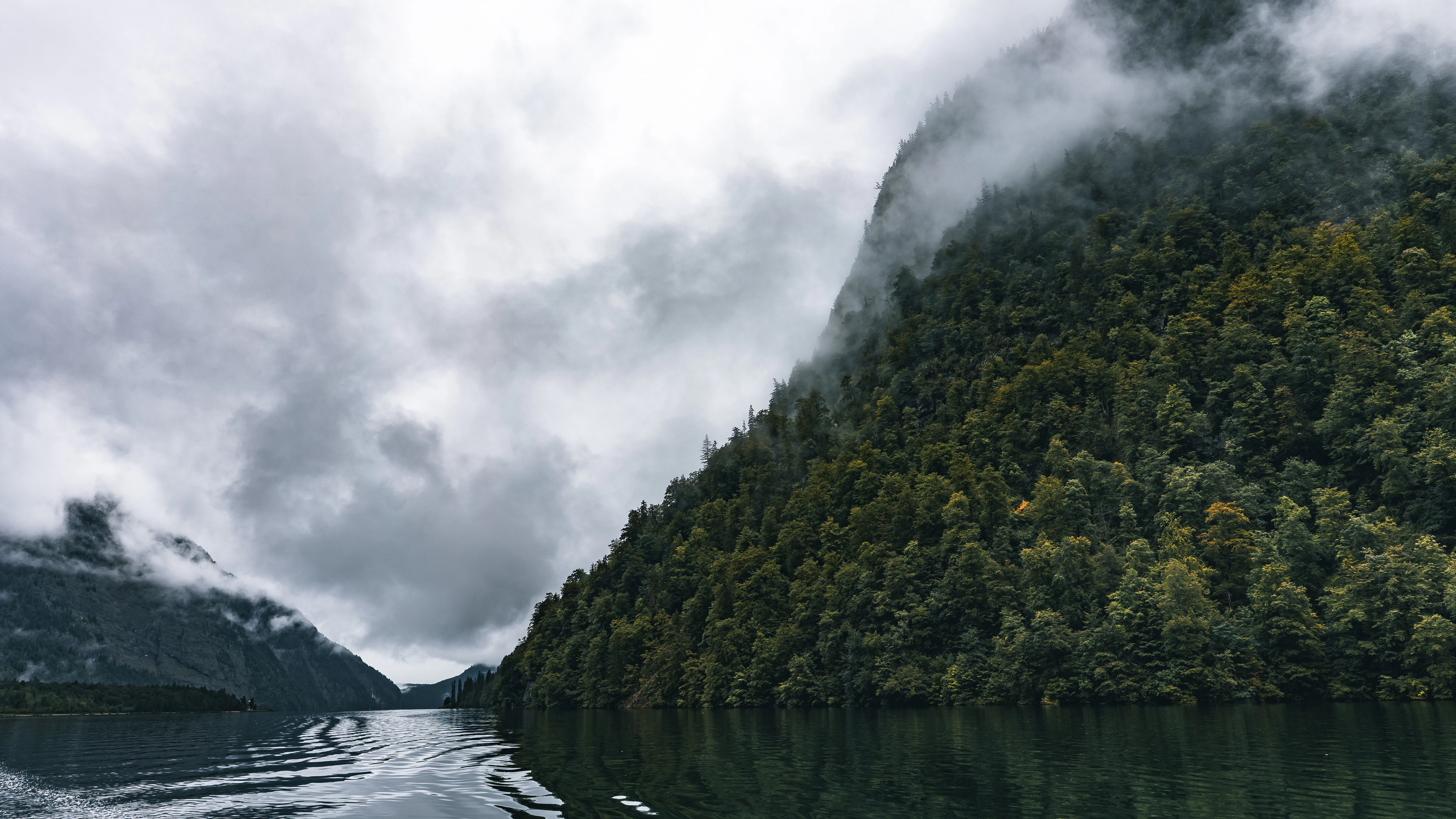 Mountains shrouded in mist loom over the water.