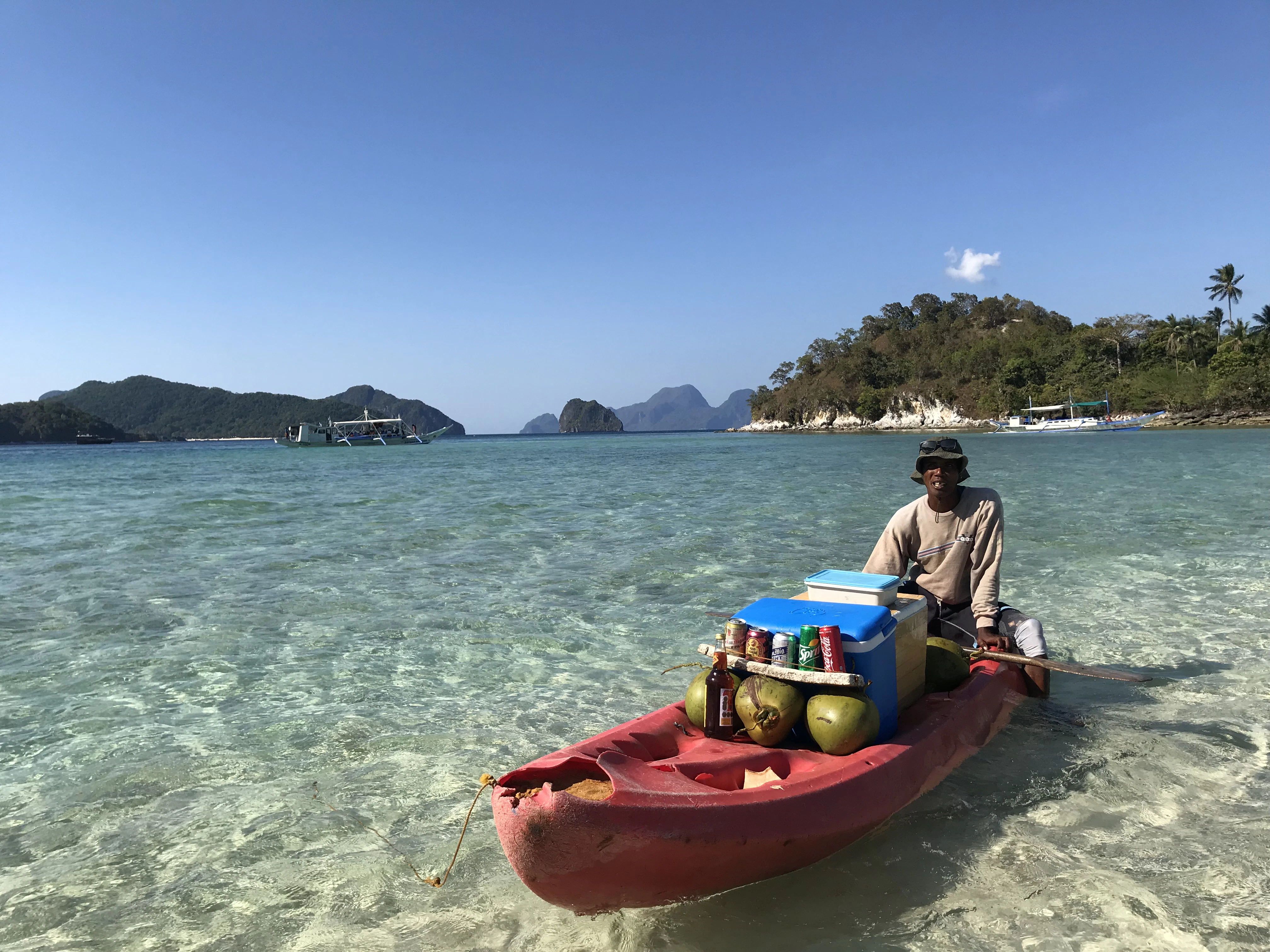 photography of man riding red kayak during daytime