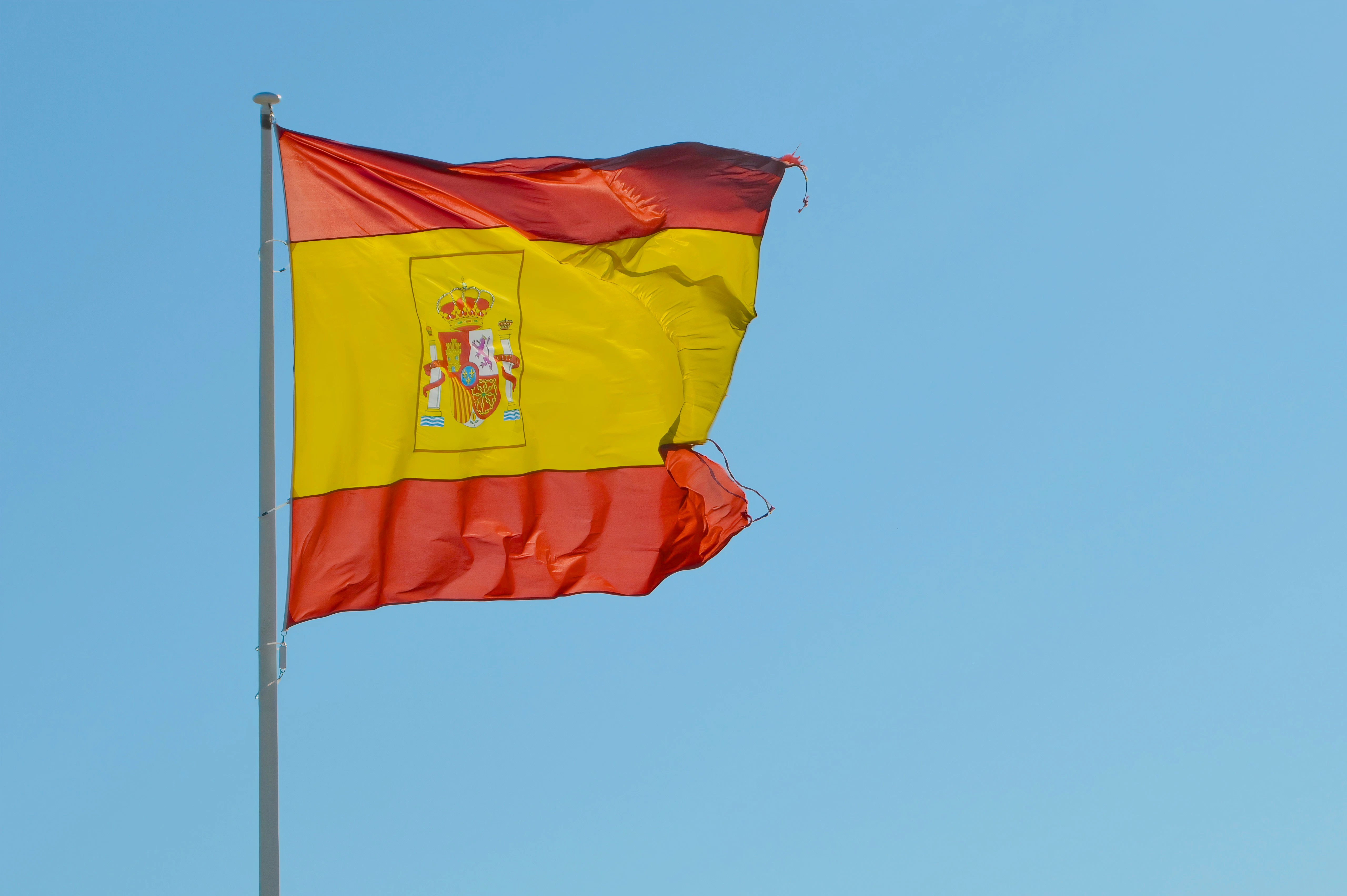 a yellow and red flag flying in the sky